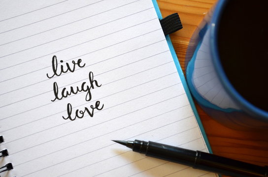 LIVE LAUGH LOVE inspirational quotation written in notebook