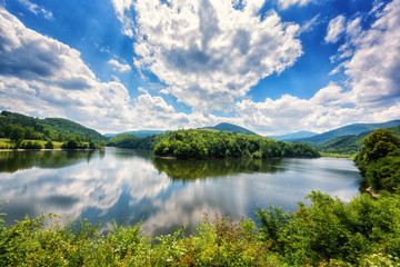 Beautiful summer daytime landscape, meander of the river with reflection, green hills and mountains and stunning blue cloudy sky. Recreation area reservoir Ruzin near Kosice, Slovakia