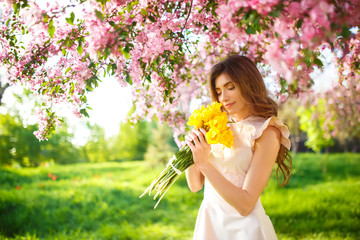 beautiful  young girl with a bouquet of yellow tulips. Good spring mood. 
