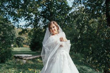 Fototapeta premium The charming bride stands in the park