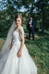 Fototapeta premium The charming bride stands in the park