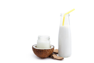 organic coconut oil in glass jar and coconut milk in glass bottle isolated on white, coconut drink concept