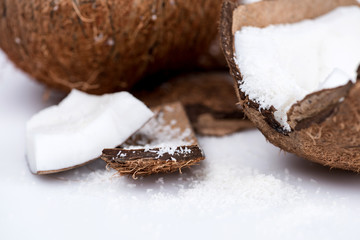 close up view of ripe organic coconut with sweet shavings isolated on white