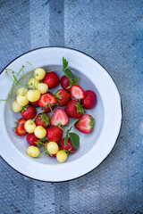 Plate with berries on a gray. top view