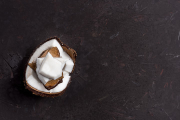 top view of pieces of ripe tropical coconut on dark background