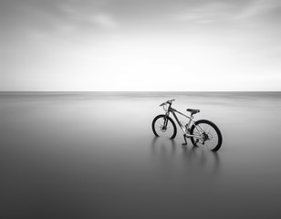 Vélo (VTT) sur la plage longue exposition noir et blanc