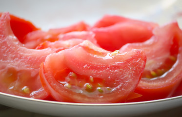 Salad of ripe red juicy tomatoes in a plate close up