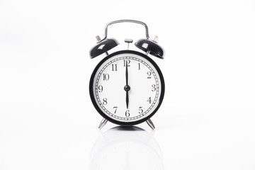 black alarm clock isolated on white table background and reflect.