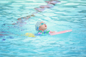 Fototapeta na wymiar Children girl in swimming pool