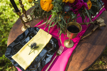 Wedding decor with fruit, flowers, candles on a table in style of a boho-chic. Decoration of a wedding photoshoot. Details of a wedding decor.