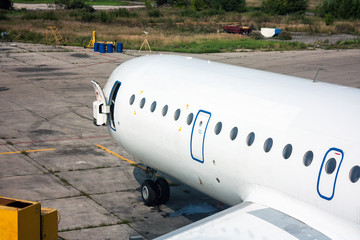 Close-up of the front of a passenger aircraft with an open door on the aviation technical base