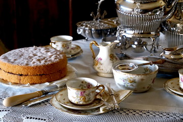Fresh Victoria Sponge and tea making essentials on a traditional English table
