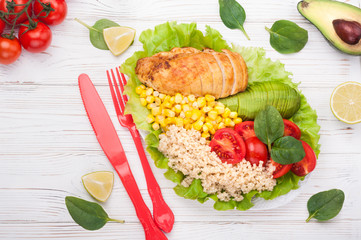 Buddha bowl. Healthy dinner with quinoa, chicken, tomatoes, avocado, spinach and lettuce leaves.  Healthy salad bowl on white background. Top view