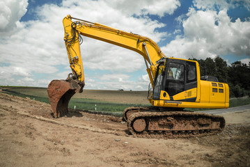 Yellow excavator standing on mud ground