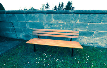 Brown bench in front of a wall