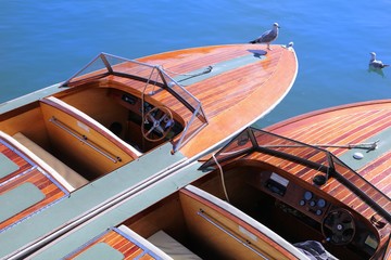 Two classic wooden speedboats moored in blue water ready to take passengers on an ocean trip