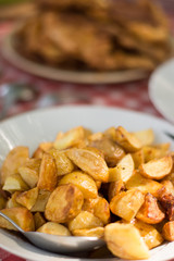 Fried young potatoes served on the lunch table with steaks in th