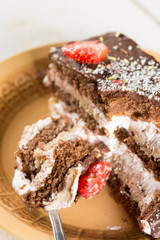 Closeup macro slice of chocolate cake with strawberries on the p