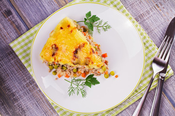 Meat, potato, cheese, carrot, onion and green peas casserole. Traditional shepherd pie. View from above, top studio shot