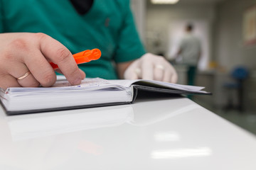 The doctor writes in a notebook at the clinic