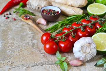 Food background with different ingredients on a marble background. Cherry tomatoes, rosemary, garlic, pepper, lime. Top view.