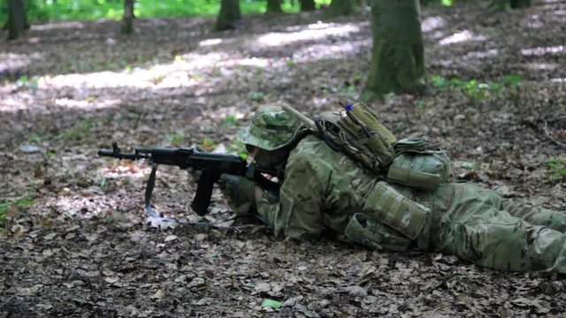 Guerilla partisan warrior aiming in forest ambush carrying his gun. Partisan war reconstruction.