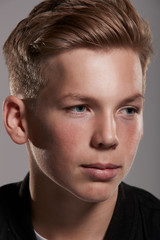 Fototapeta premium White teenage boy looking away, close up portrait, vertical