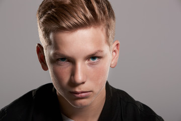 Fototapeta premium White teenage boy looking up to camera, head and shoulders