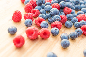 Heidelbeeren und Himbeeren auf Holz Hintergrund