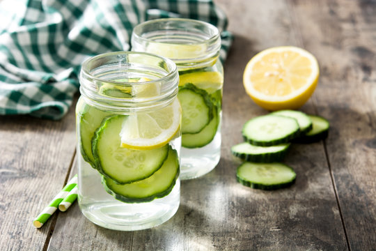 Detox water with cucumber and lemon on wooden table
