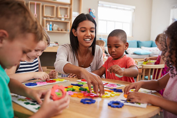 Teacher And Pupils Using Flower Shapes In Montessori School