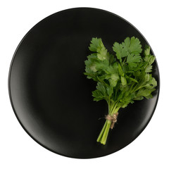 Parsley on a black plate isolated on white background.