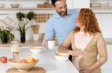 Obraz na płótnie Canvas Adorable shot of husband talking to pregnant wife