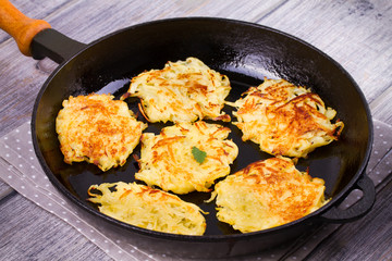 Potato Pancakes. Vegetable fritters. Latkes in frying pan