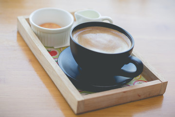 hot coffee with foam milk art in afternoon break(selective focus, vintage effect)