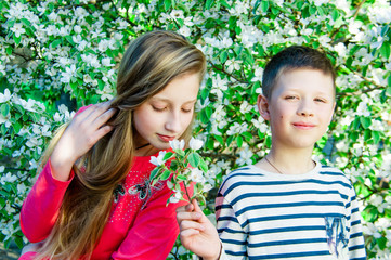 The boy gives flowers to the girl