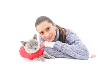 A woman wears a purple sweater and white gloves with a Siamese cat wearing a red sweater