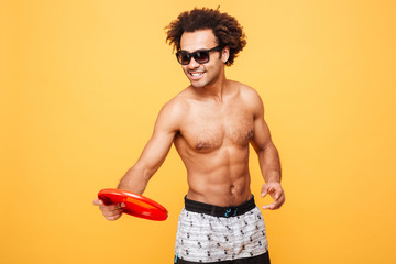 Portrait of a african man in sunglasses holding frisbee