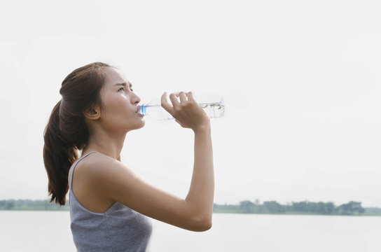 Beautiful women drink bottled water after exercising