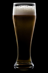 A glass of beer, on a black background, with shiny edges and foam