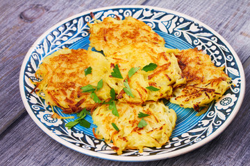 Potato Pancakes With Yogurt Sauce. Vegetable fritters. Latkes on blue plate