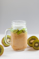 Fresh healthy fruit smoothies from kiwi, banana, pear and apple in a jar on a white background. Soft focus. Vegetarian food