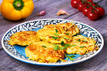 Potato Pancakes With Yogurt Sauce. Vegetable fritters. Latkes on blue plate