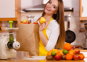 Woman in kitchen preparing fruits for juicing