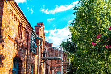 fabric building with brick wall in HDR look with green tree