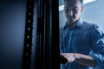 Serious young man working in the server room