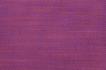 Magenta textile background with checkered pattern, closeup. Structure of the fabric macro.