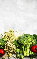 Food background, ingredients for cooking green vegetarian pasta with broccoli, spinach and tomatoes, top view, flat lay