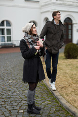 Man and woman walk in the park at sea in the spring romantic bouquet of flowers a date 