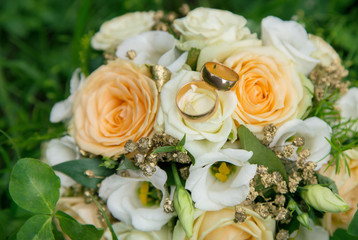 Obraz na płótnie Canvas Wedding rings on wedding bouquet bride